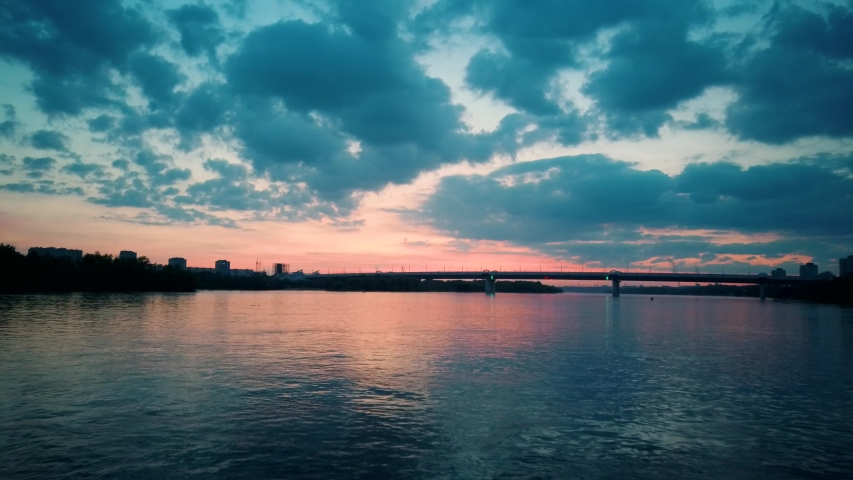 Aerial 4k view. Stunning sunset sun over the river. Flying above the surface of the water