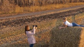 The girl makes the photo and video of teen lain on the haystack.