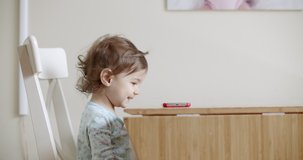 Toddler Girl Using Mobile Phone on the Table. Shot in 4K RAW on a cinema camera.