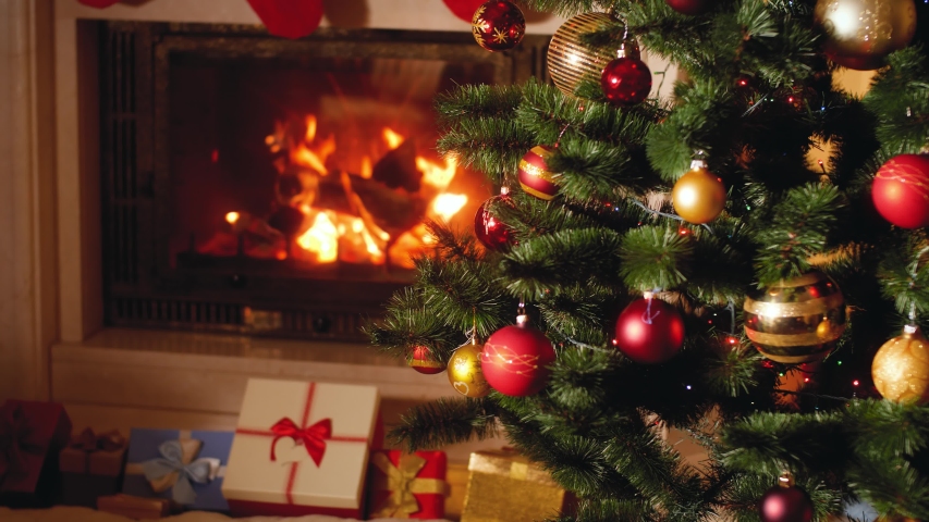 4k footage of big heap of gifts and present next to burning fireplace and glowing Christmas tree in living room on Christmas eve | Shutterstock HD Video #1039189595