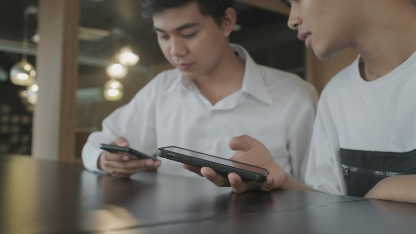 Young men using digital gadgets or mobile phone for online transfer data.