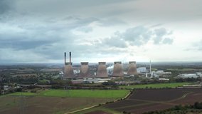 Aerial video of  coal fired power station with seven cooling towers under a cloudy sky. Ferrybridge C power station, West Yorkshire, England
