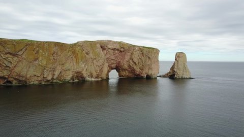 Aerial shot on a cloudy day of the Percé rock in Quebec.