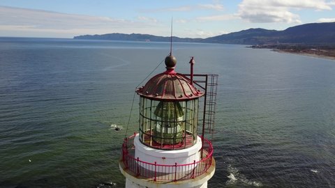 Drone shot flying away from a lighthouse location on the coastline of the Gaspé Peninsula in Quebec, Canada.
