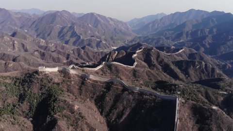 Great Wall of China lying on tops of mountains, scenic aerial view of Badaling, mountainous landscape on background. Famous landmark and popular tourist attraction. Long strip of fortification wall