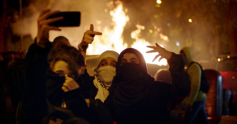 BARCELONA, CATALUNYA, SPAIN - CIRCA October 2019 . Young teenagers rebel riot anarchists taking selfies on fire chaos as protest for independence 