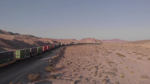Barstow, California/USA - October 12, 2019: Freight train travels through desert canyon stacked with transport containers.