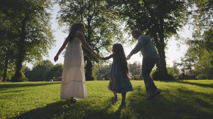 Back view of parents and daughters walking in the park and enjoying the beautiful summer nature. | Shutterstock HD Video #1039232015