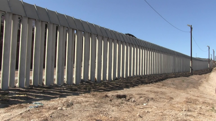 U.S. Mexico concrete pillar border wall between San Diego and Tijuana looking southwest along the wall.