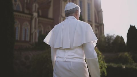 Religion: Pope walks through the Vatican garden at sunset. Slow motion