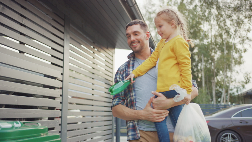 Happy Father Holding a Young Girl and Going to Throw Away an Empty Bottle and Food Waste into the Trash. They Use Correct Garbage Bins Because This Family is Sorting Waste and Helping the Environment. | Shutterstock HD Video #1039252385