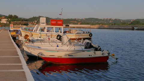 KERKYRA, GREECE - JULY 05, 2019: Pleasure and fishing boats moored at the pier of the church of St. Vlacherna. The coast of Corfu, Cape Kanoni, Greece. Mediterranean