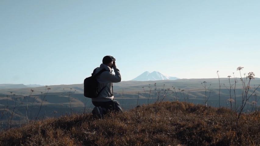 man makes a photo in the mountains