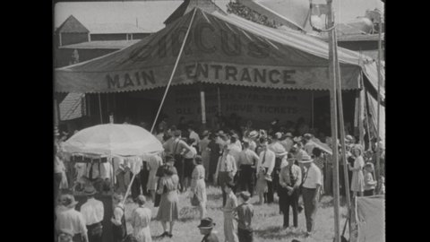 1940s Ringling Brothers and Barnum Bailey Circus Tents and Entrance. A little Girls Buys Cotton Candy. Horses, Clowns, and Marching Bands Parade into the Big Top. A Boy and Grandfather Eat Popcorn. 