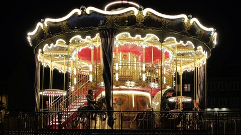 Gdansk, Poland - July 23, 2019: Vintage children's carousel illuminated at an amusement park at night