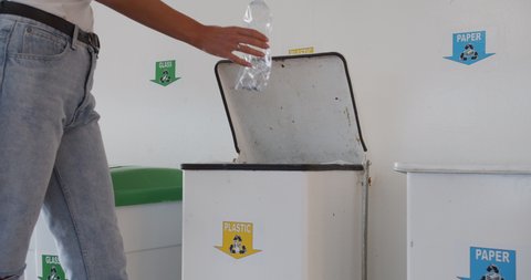 The girl throws a plastic bottle in a special container. Recycling plastic, proper sorting of garbage.
