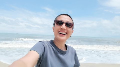 The woman kept me. Skinhead was happily selfie by the sea.