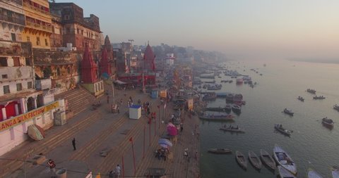 Drone shot flying down the crowded coastline of the city of Varanasi, India.