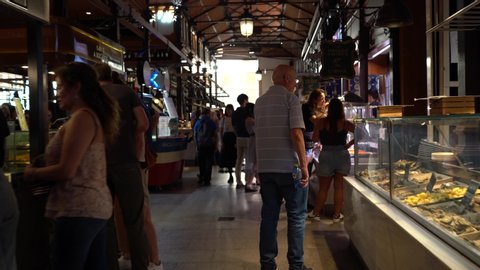 MADRID, SPAIN - OCTOBER 2019: People visiting and enjoying drinks and tapas inside the historical "Mercado de San Miguel", a popular market among tourists, located in the center of Madrid, Spain. POV.