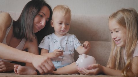 Mother and two children saving money to piggy bank. Family earning money for future. Investment concept.