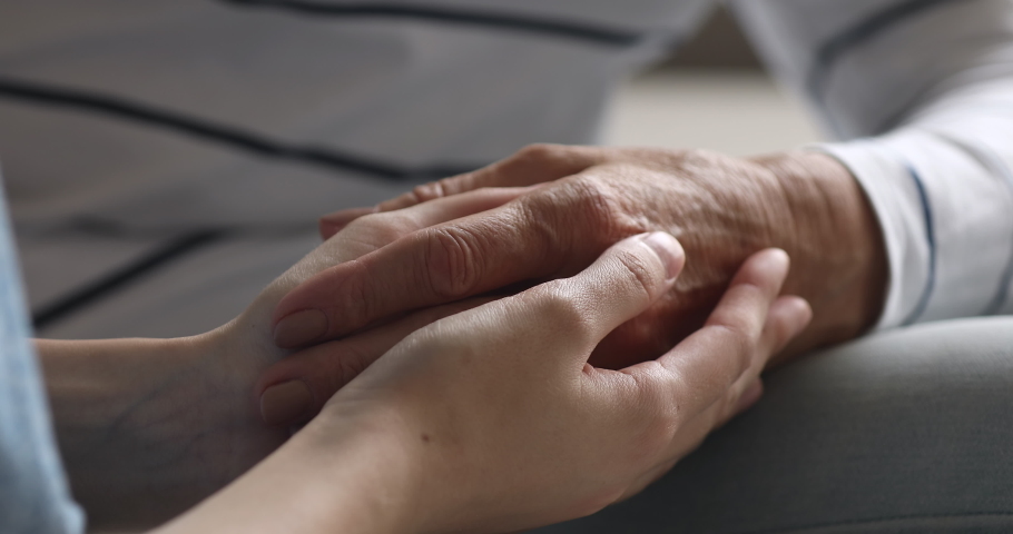 Close up view of young female hands holding old grandma arm as concept of elderly people health care assistance, older grandma support, help in problems, women generations comfort, hope and kindness | Shutterstock HD Video #1039317797