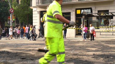 Barcelona, Spain 10 19 2019 - road workers repairing a roadway against a burnt bus stop