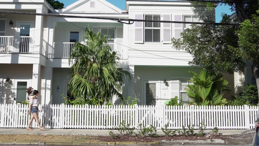tourist woman strolling in front historic house in key west
