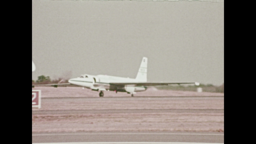 1970s: Planes travels across runway. Men on boat. Rocket launches.