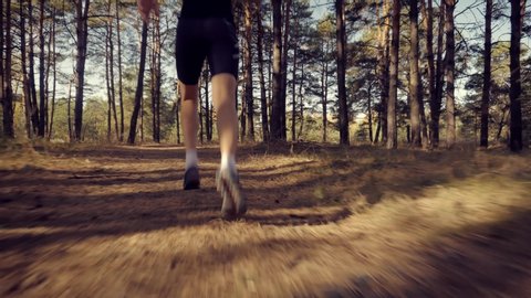 Runner Man Fit Athlete Legs Jogging On Trail Ready To Triathlon. Marathon Runner Jog On Forest. Running Man Sport Workout. Triathlete Running,Sprinting And Endurance Workout Training. Sport Concept.