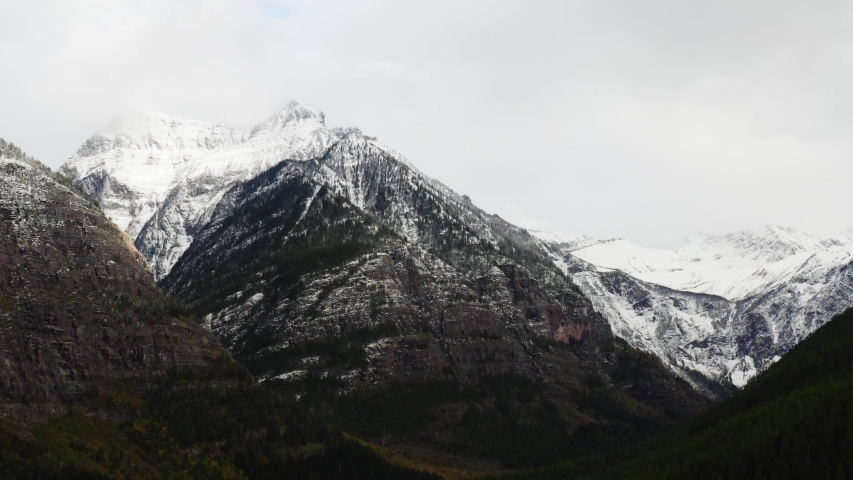Aerial view of Glacier National Park, breathtaking landscapes of Montana, snowy mountain peaks and endless green forest, moody shoots of nature