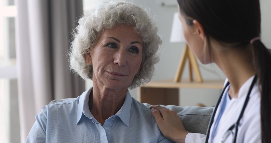Senior old woman talking to young female nurse doctor help patient at checkup medical consultation at home hospital, elderly grandma listen caregiver giving support, older people healthcare concept Royalty-Free Stock Footage #1039338032