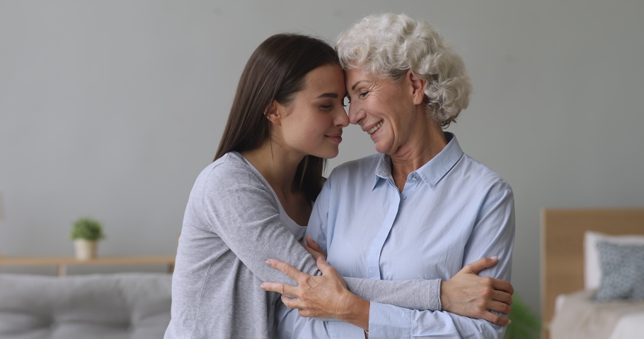 Loving young adult woman daughter hug elderly grandma at home, affectionate two women generation family old mother bonding embrace granddaughter express tenderness care support enjoy reunion concept | Shutterstock HD Video #1039338071