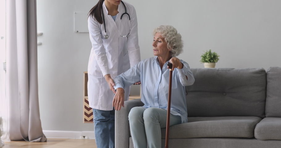 Young woman nurse caregiver help disabled old senior grandmother patient hold cane stick in retirement house, female doctor carer provide elderly lady medical service, older people healthcare concept Royalty-Free Stock Footage #1039338179
