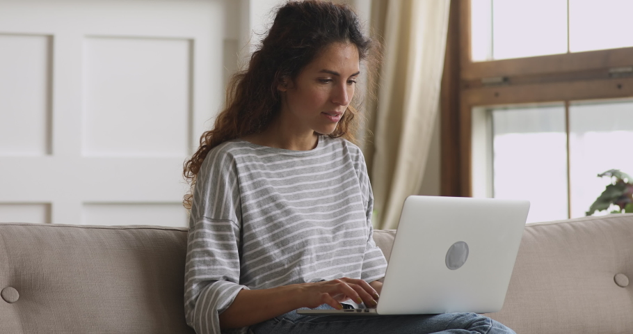 Euphoric amazed young woman winner using laptop look at screen feel excited overjoyed lucky scream yes celebrate success online bid win victory read good online news on computer sit on sofa at home Royalty-Free Stock Footage #1039338182