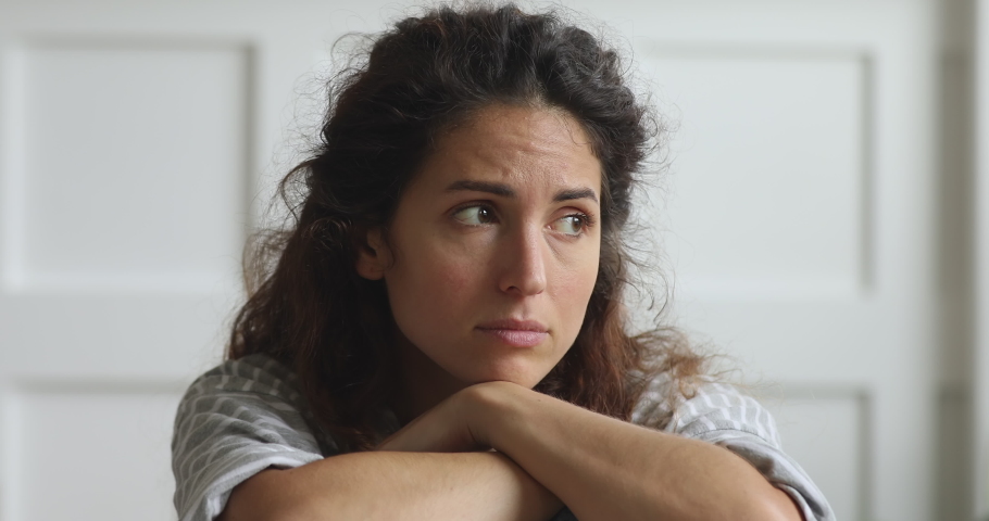 Unhappy thoughtful young woman sad face looking away thinking of problem feel depressed frustrated lonely at home alone, upset heartbroken lady suffer from anxiety made bad mistake, close up view | Shutterstock HD Video #1039338230