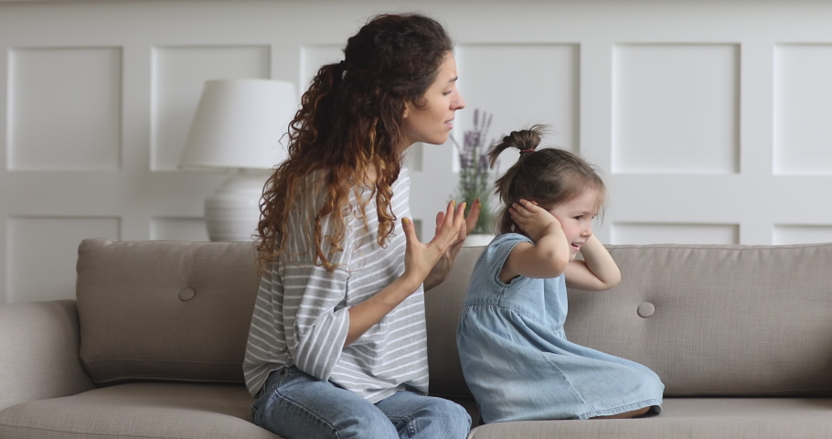Angry young adult mother scolding shouting at stubborn difficult rebellious little kid child daughter close ears not listening ignoring frustrated mom demand discipline during family quarrel at home Royalty-Free Stock Footage #1039338236