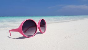 Pink sunglasses left on the sandy white beach at the Caribbean 4K footage