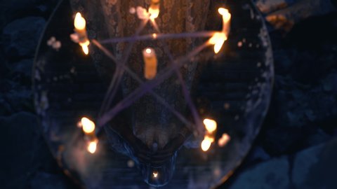 Mysterious pentagram on ritual mirror, reflection of occult magician with candle