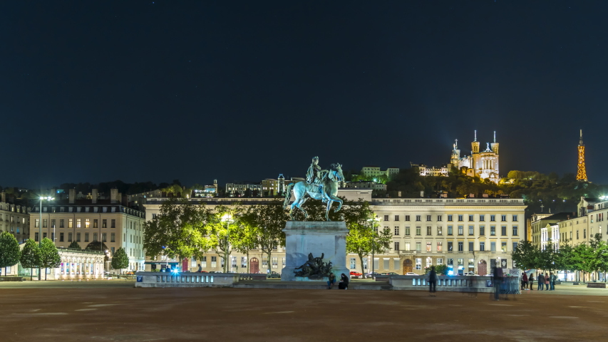Lyon france at night square time lapse. Equestrian statue of louis XIV on the Bellecour Square and Notre Dame de Fourviere in Background