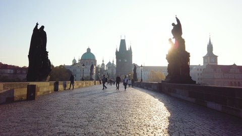 Prague, Czech Republic - October 15, 2019: Hyperlapse view of Charles Bridge in Prague, Czech Republic showing medieval tower and statues of saints at sunrise
