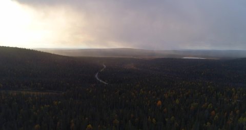 Rainy weather in Lapland, Aerial, drone shot, over fall color forest, towards rain above arctic wilderness, on a dark, autumn day, in Pallas-Yllastunturi national park, Muonio, Finland