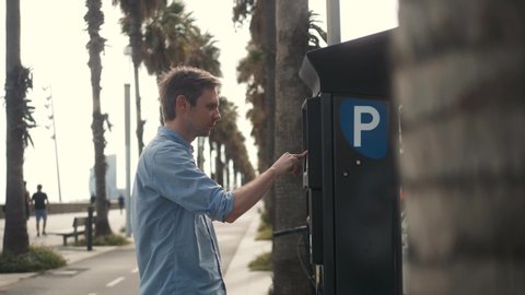 man inserting a parking lot ticket at an automated pay machine pay with card. Cash Automated machines parking lot in city attendants.