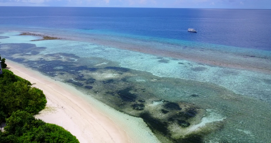 Tropical Lagoon with Clear Blue Water and Coral Reef in Thailand. Vacation and Travel Concept. aerial drone wide tilting up dolly in establishing shot