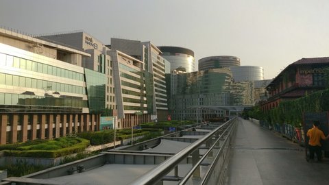 Gurgaon, India - circa 2019: Panning shot of empty walkway at cyberhub gurgaon showing office buildings and restaurant pubs. Shows offices like DLF innov8, Toshiba, Oppo and restaurants like