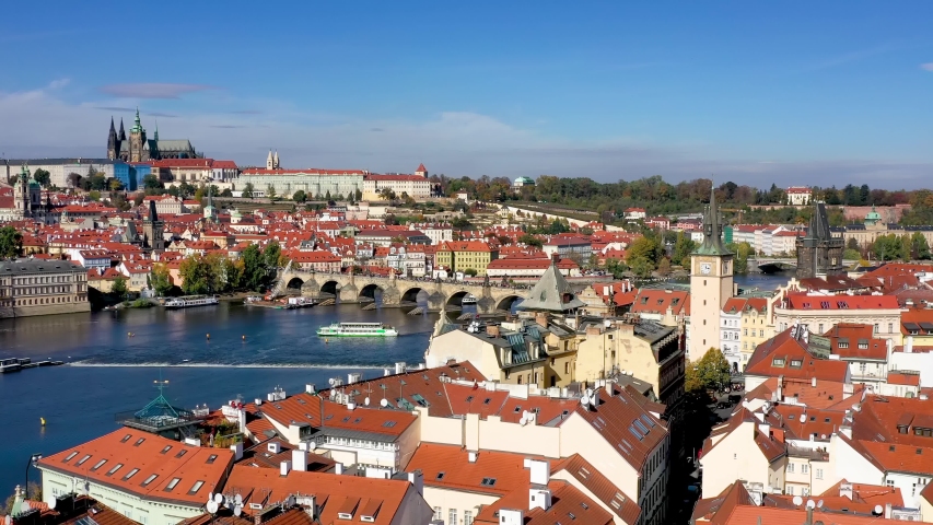 View over the rooftops to the famous Charles Bridge in Prague, Czech Republic, leading to the old Lesser Town and Castle during a sunny autumn day