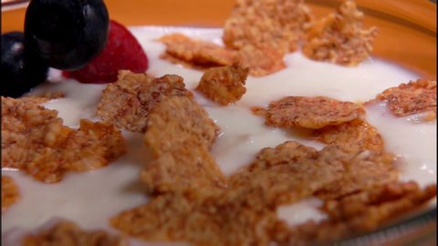 Healthy breakfast: raspberries and blueberries fall on yogurt with cornflakes
