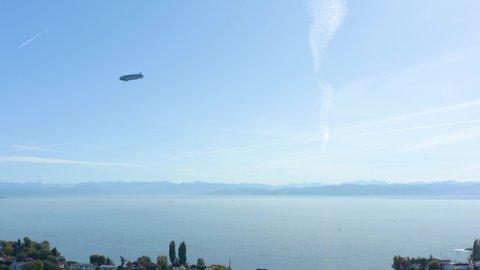 Aerial view of the city Immenstaad beside the lake Constance in Germany on a sunny day in autumn, fall. Tracking a blimp in the sky.