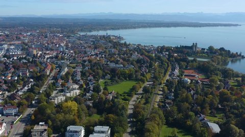 Aerial view of the city  Friedrichshafen beside the lake Constance in Germany on a sunny day in autumn, fall. Pan to the right from the city to the lake.