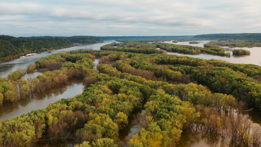 Aerial view of Upper Mississippi river (bottomland forests, open water, wetlands, islands) at Wisconsin Minnesota border. Autumn fall season (october). Landscape from above, drone shot. Sunrise, sunny
