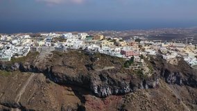 Aerial drone video of beautiful picturesque village of Fira built on top of a cliff with breathtaking view, Santorini volcanic island, Cyclades, Greece